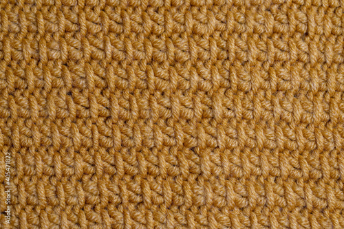 The texture of the knitted fabric of yellow mustard yarn. Traditional hobby.