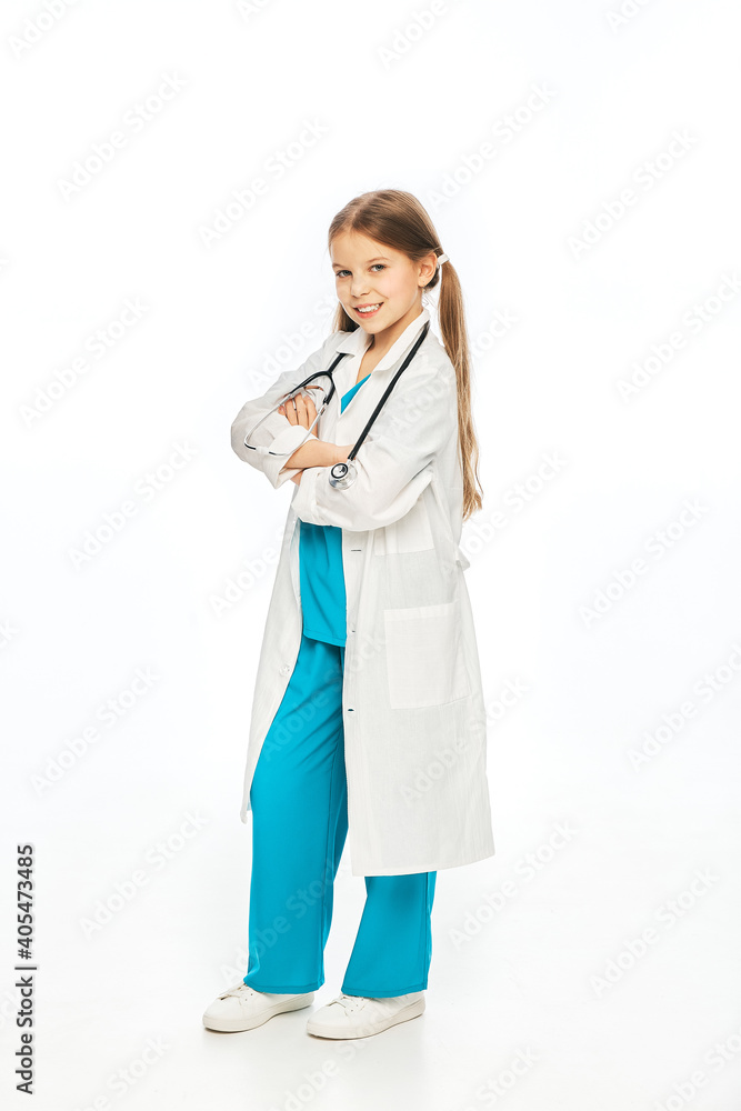Positive girl wearing a medical coat and stethoscope, posing and looking at camera, full length. Isolated on white background Positive girl wearing a medical coat and stethoscope, posing and looking at camera, full length. Isolated on white background