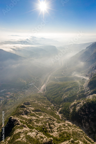 aerial drone shot of highway through Montserrat mountain near Barcelona with morning fog