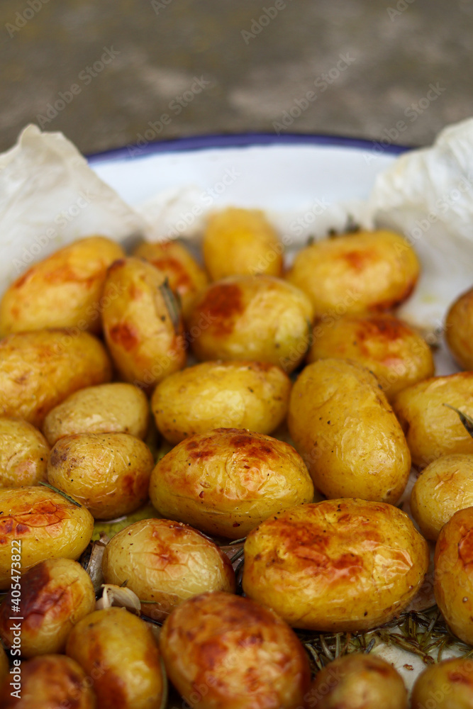 SIde view at baked potatoes in a casserole on parchment paper SIde view at baked potatoes in a casserole on parchment paper