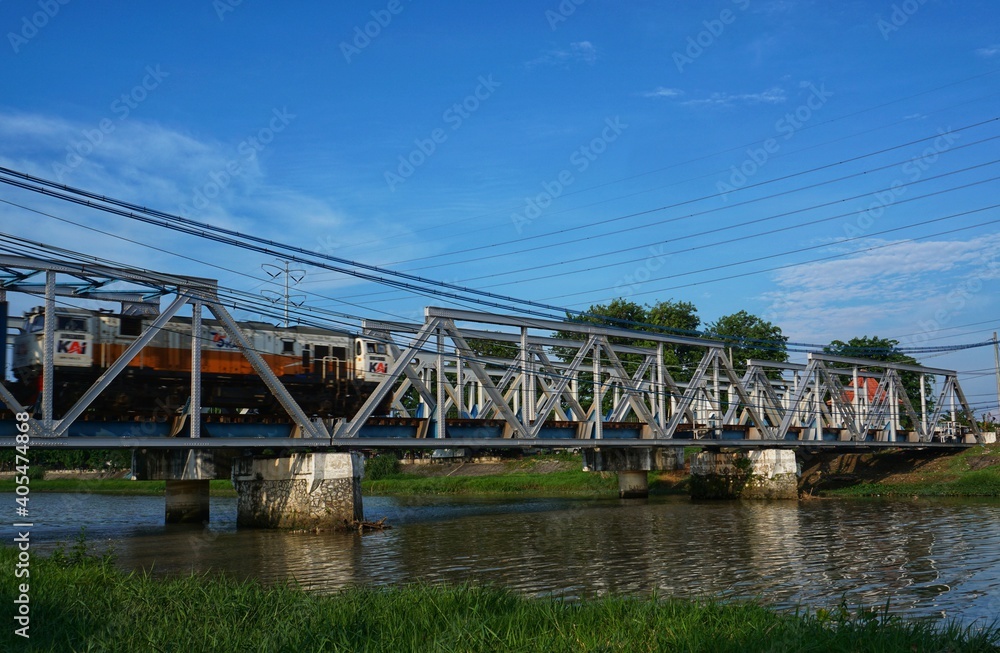 Semarang, Indonesia - 20 November 2020; The train is crossing the bridge in the west flood canal, Semarang Semarang, Indonesia - 20 November 2020; The train is crossing the bridge in the west flood canal, Semarang