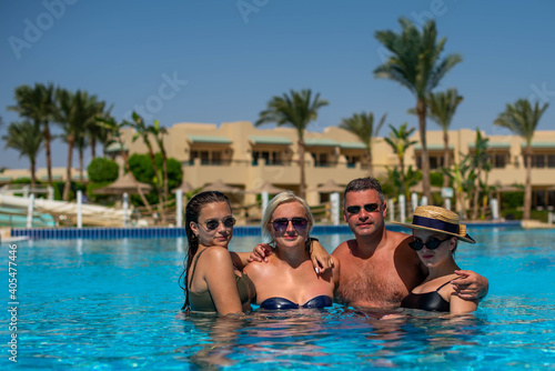 Real people concept, beautiful family, two teenage girls, mother and father swimming and having fun in pool in vacation. happiness and nice body for enjoyed people live an lifestyle as vacation © MartaKlos