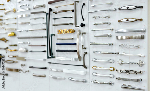 Big selection of handles cabinets parts on a white background shop window. samples of Metal and Stainless Steel handle styles on wooden kitchen cabinet with different Stainless Steel handles photo