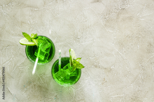 Green iced cocktail drink witn lime and mint, top view