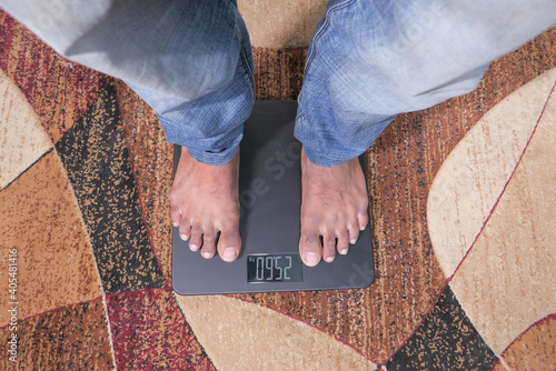  man's feet on weight scale top view 