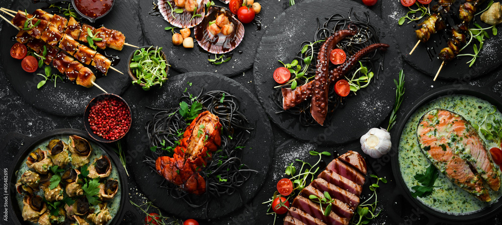 Seafood dishes: salmon, octopus, tuna and rapana on a black stone background. Big banner. Flat Lay.