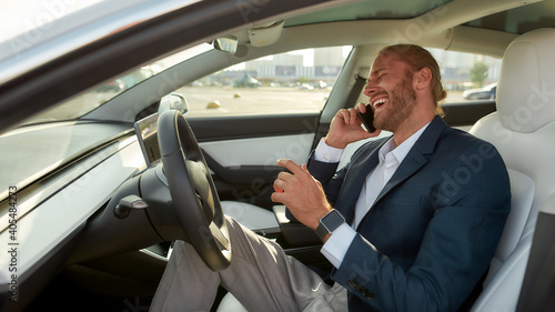 Laughing young businessman on driver seat in car © Svitlana