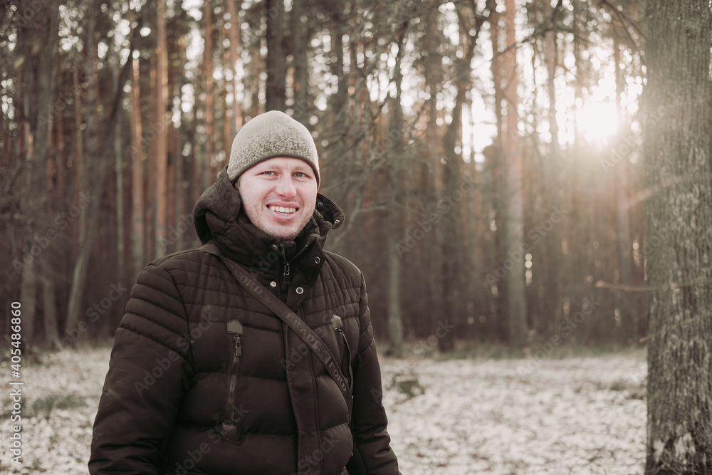 Smiling man in the winter forest. Happy man walks in the snowy forest. A guy in a good mood. Hike through the winter forest. Winter travel. Nature walk Smiling man in the winter forest. Happy man walks in the snowy forest. A guy in a good mood. Hike through the winter forest. Winter travel. Nature walk