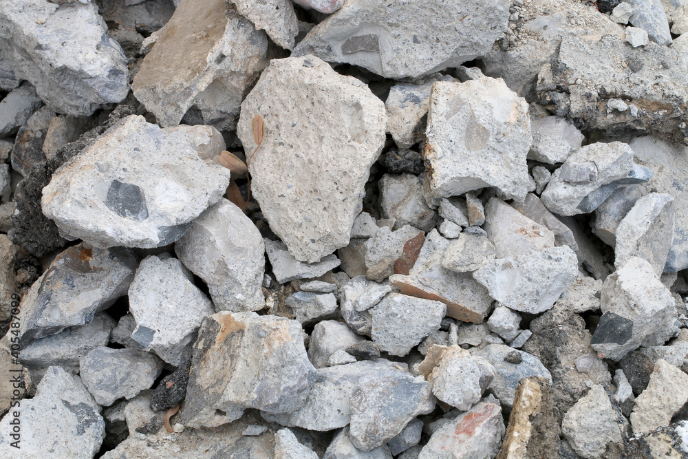 broken concrete floor at building construction site. cracked concrete texture background. Grey surface with cracks close up. A lot of pieces of splintered plaster. Abstract concept of split, dissent,