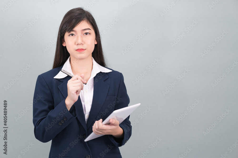 Woman in suit using computer digital tablet on gray Woman in suit using computer digital tablet on gray