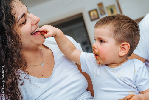 Boy eating chocolate while playing with mom