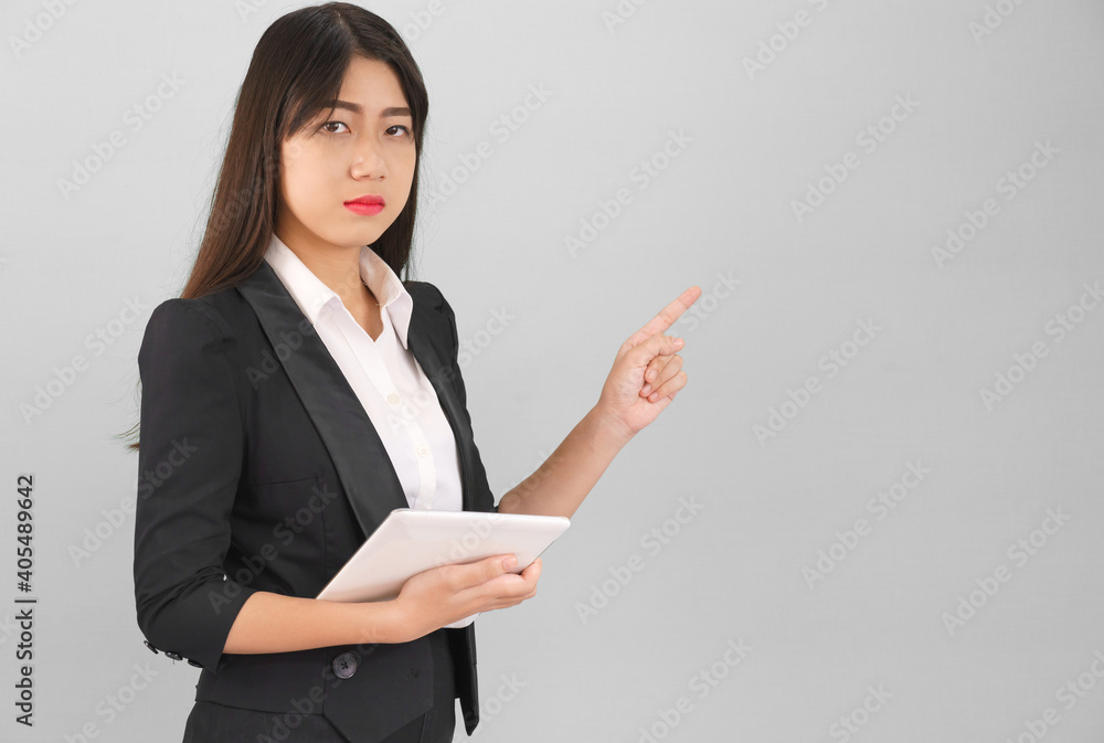 Asain women in suit standing using digital tablet and pointing finger Asain women in suit standing using digital tablet and pointing finger