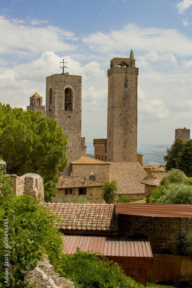 View of the city skyline of San Gimignano in the background are typical stone houses and towers. It is popular summer travel destination, Europe, Italian