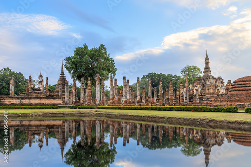 Buddha statue and pagoda Wat Mahathat temple with reflection, Sukhothai Historical Park, Thailand