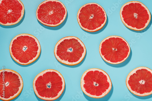 Patterns of slices of juicy Grapefruit on a blue background, a beautiful pattern.