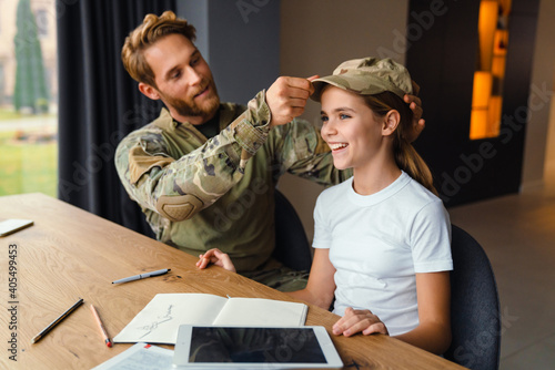 Masculine happy military man making fun with her daughter