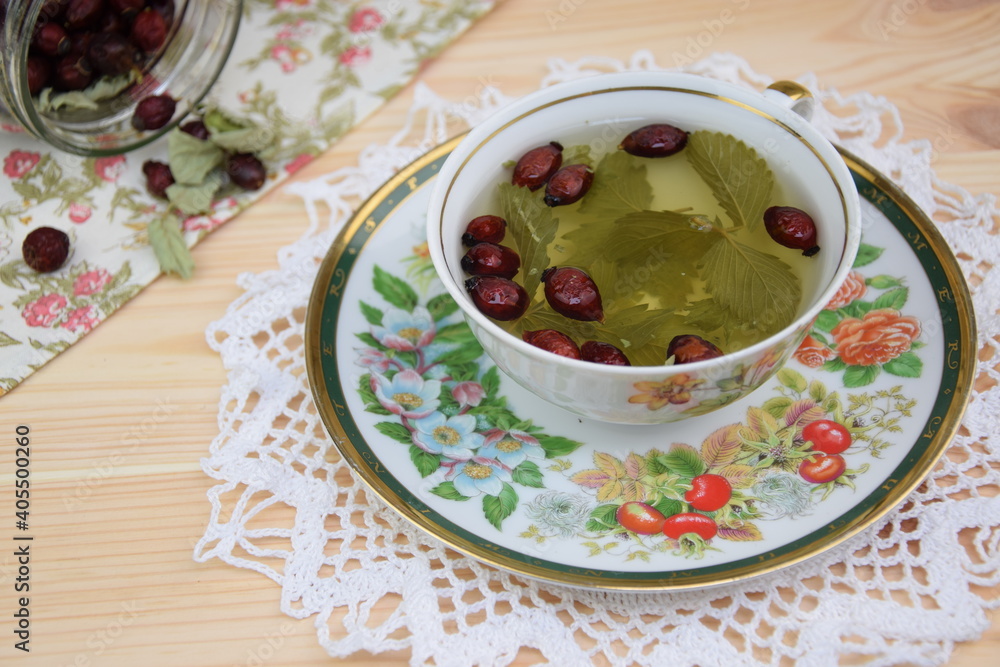 Rosehip tea with wild strawberry dried leaves, herbal tea in the beautiful cup Rosehip tea with wild strawberry dried leaves, herbal tea in the beautiful cup