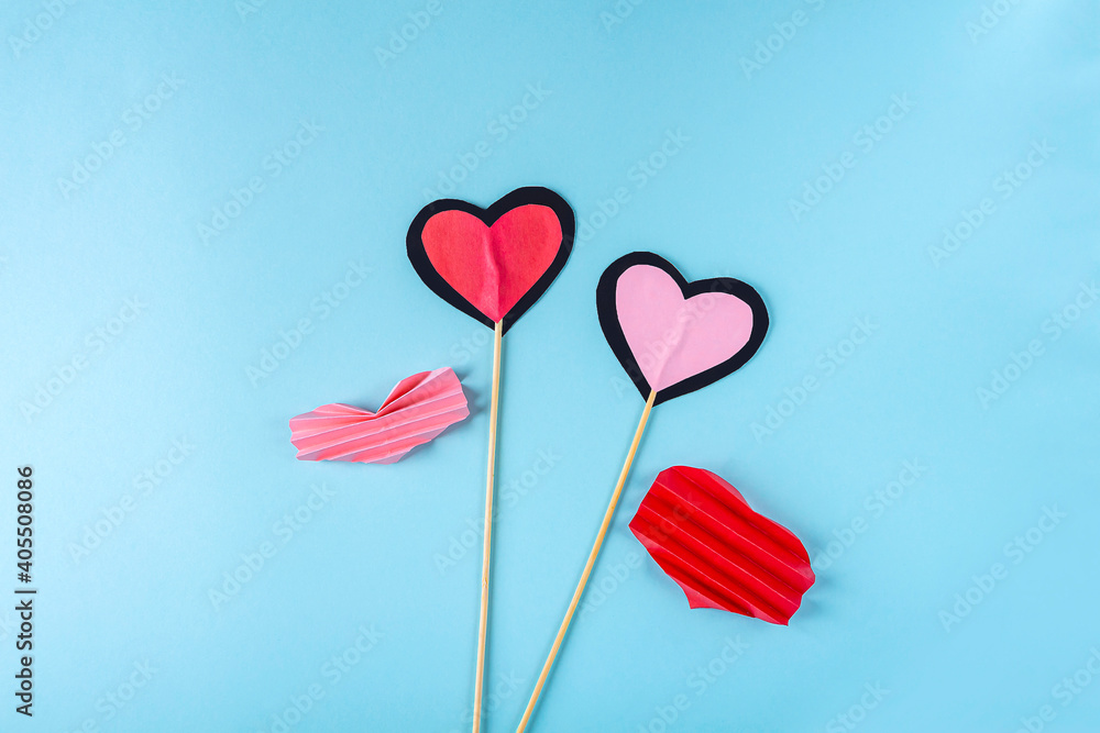 DIY and kid's creativity. Step by step instruction: how to make paper valentine heart on wooden stick. Step6 glue wood sticks between two hearts. Craft for Valentines day.