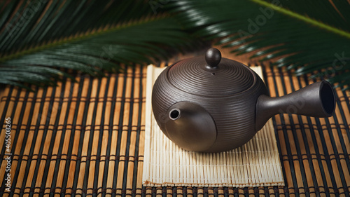 Kyusu, teapot used in making japanese green tea on wooden background banner, copy space. Wabi sabi concept, selective focus. Minimalism. Vintage effect. photo