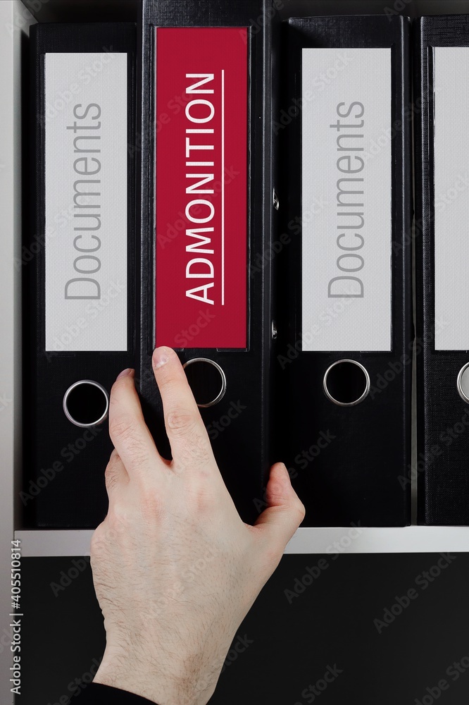 Admonition. Folder with label on the shelf of a lawyer. Red label with text in focus. Admonition. Folder with label on the shelf of a lawyer. Red label with text in focus.