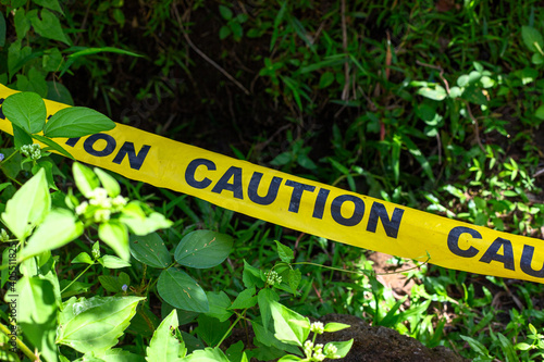 Wallpaper Mural Yellow ribbon with caution inscription over green garden. Caution barricade tape on green grass. Summer park accident place surrounded by yellow caution tape. Stop sign alert ribbon Torontodigital.ca