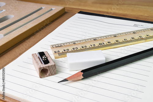 pencil, eraser,ruler with book on woodtable © piyaphunjun