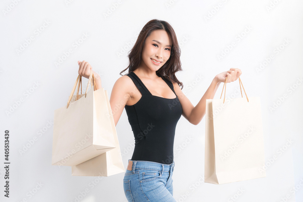 Happy beautiful asian woman black long-haired woman wearing a black shirt carrying shopping bags on isolated gray background, Shopping summer sale concept. Happy beautiful asian woman black long-haired woman wearing a black shirt carrying shopping bags on isolated gray background, Shopping summer sale concept.