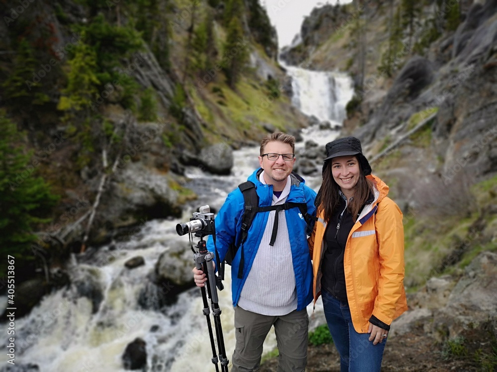 Adventure travel couple enjoying hiking and photography while staying socially isolated in bubble with mountains and waterfalls in forest