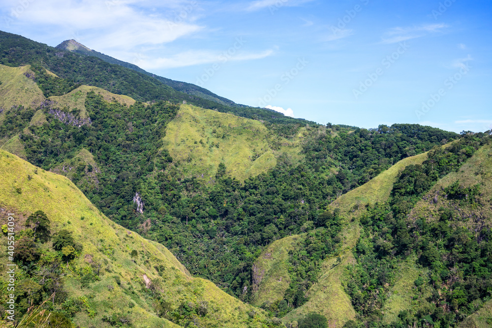 Fototapeta premium Tropical island landscape with hills, mountains and trees. Volcanic island panoramic view. Natural hiking trail in Philippines. Summer natural parkland. South Asia ecotourism. Summer vacation outdoor