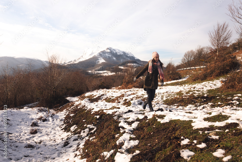 Young woman walking on a snowy mountains