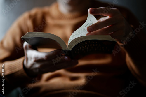 Man reading book at home hands and book closeup.