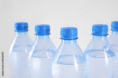 Plastic bottles with pure water on white background, closeup