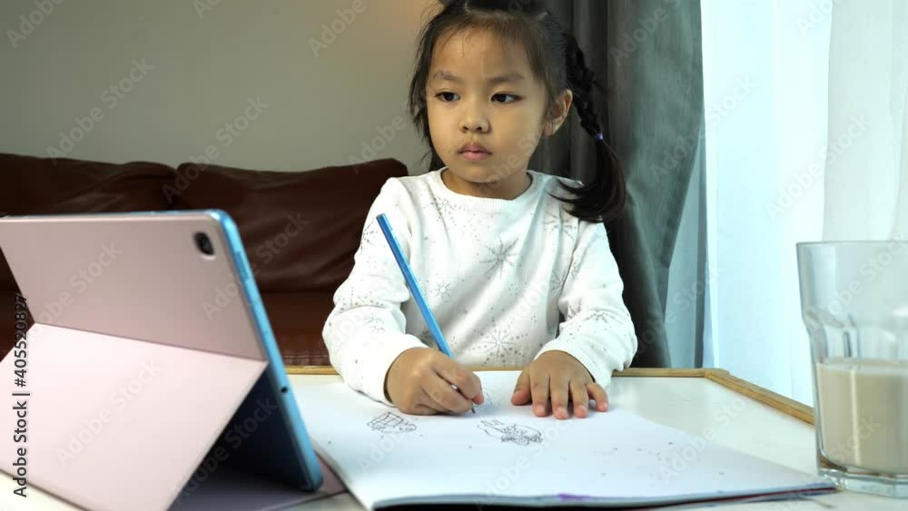 Little child girl using tablet to study online Little child girl using tablet to study online