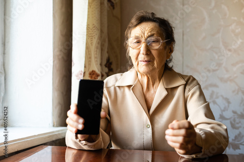 Female senior with her smartphone, a very old woman shows her phone photo