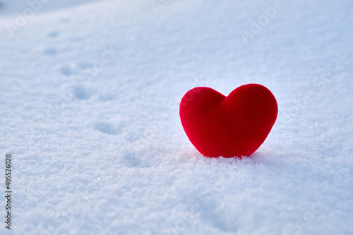 A red hot heart lies on the cold snow.