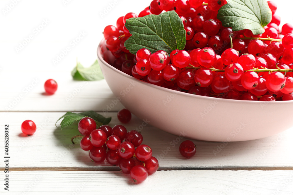 Delicious red currants and leaves on white wooden table, closeup Delicious red currants and leaves on white wooden table, closeup