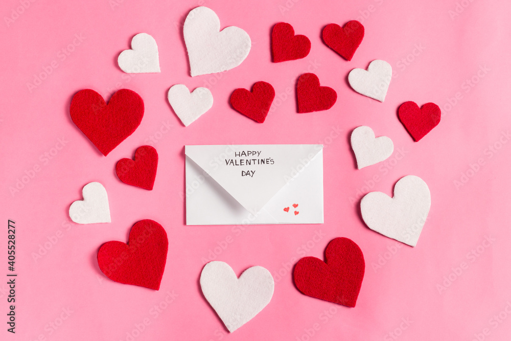 Valentine's day flat lay on the pink background. Red hearts and envelope with a love message. Conceptual image for February 14th. Flat lay, top view