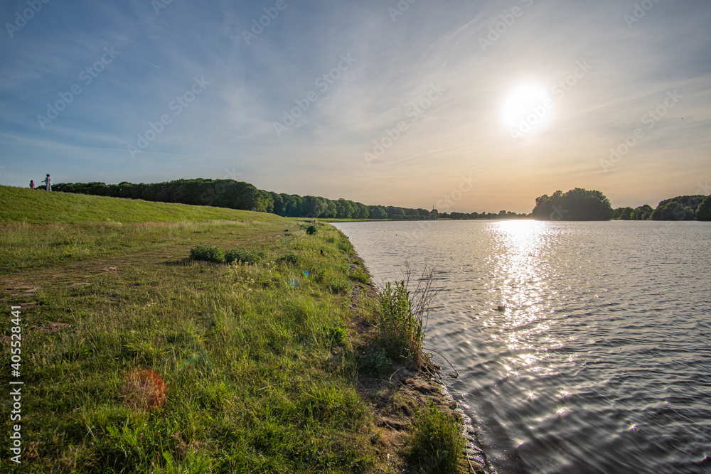 green field at beautiful werdersee, a river in bremen, at sunset
