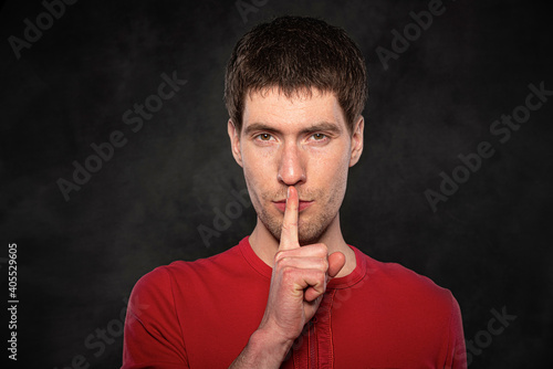 Funny young guy portrait isolated on dark background.