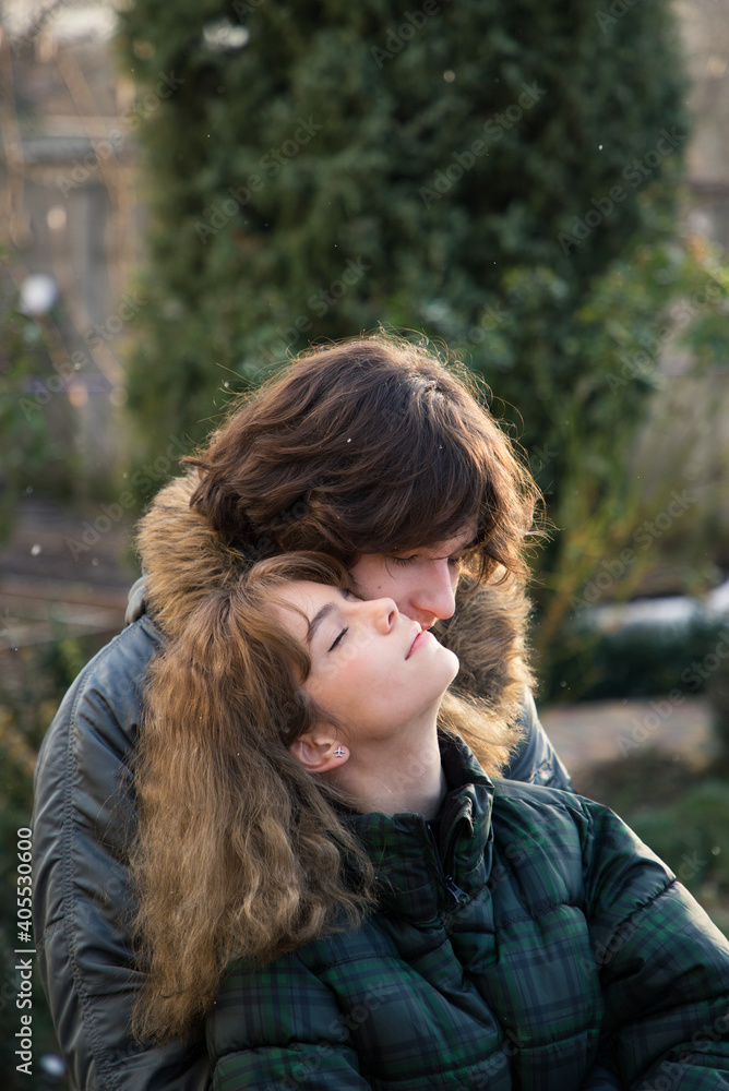 enamored young guy and teenage girl hug, enjoy the moment. Outdoors during the cold season of the year. Joyful meeting, tender feelings. Valentine's Day
