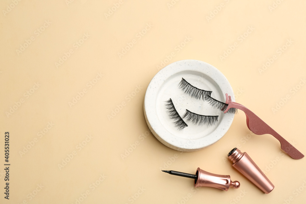 Flat lay composition with magnetic eyelashes and accessories on beige background. Space for text - obrazy, fototapety, plakaty 