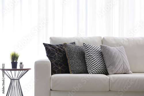 Comfortable sofa with different soft pillows indoors