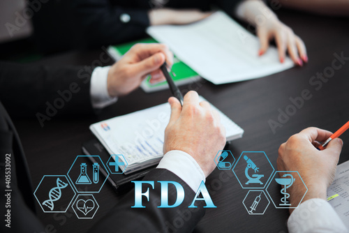 A group of doctors in a modern clinic is planned. The concept of modern medicine and medical biotenology. Medical icons on the screen with the inscription: fda