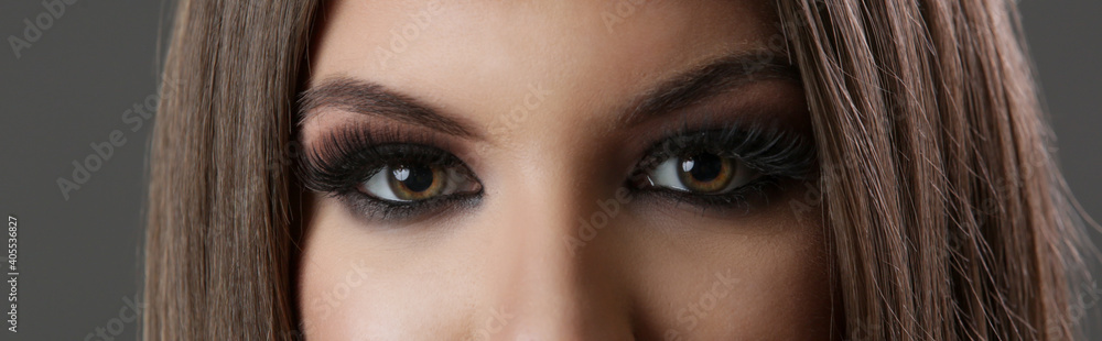 Close up of woman eyes with smokey eyes makeup and fake lashes, studio shot, looking to camera. Close up of woman eyes with smokey eyes makeup and fake lashes, studio shot, looking to camera.