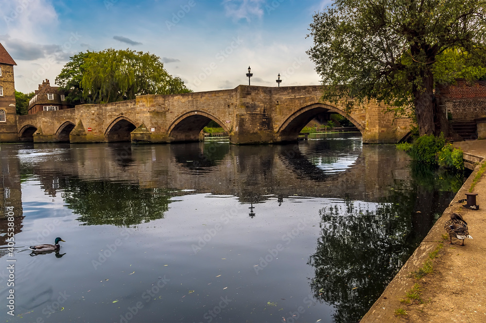The old bridge at Riverside, Godmanchester reflected in the River Great Ouse in springtime
