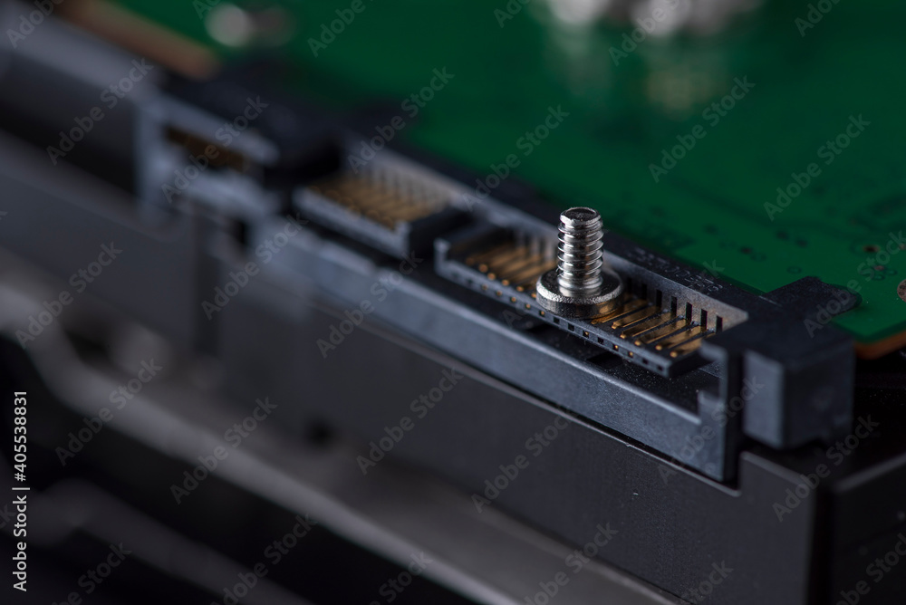 Component parts of a disassembled hard drive, close-up on a dark background. Component parts of a disassembled hard drive, close-up on a dark background.
