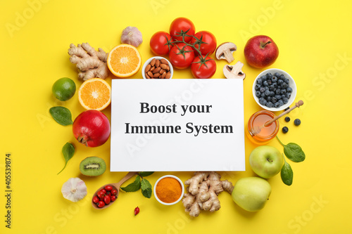 Set of natural products and paper sheet with text Boost Your Immune System on yellow background  flat lay