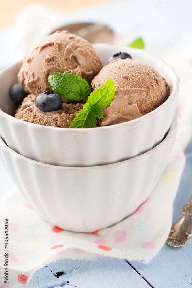 Chocolate ice cream with mint and fresh berries on blue wooden background, top view. Chocolate ice cream with mint and fresh berries on blue wooden background, top view.