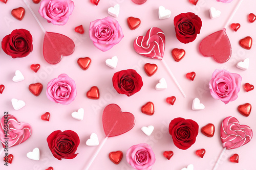 Valentines Day background with red and pink roses and heart shaped candies