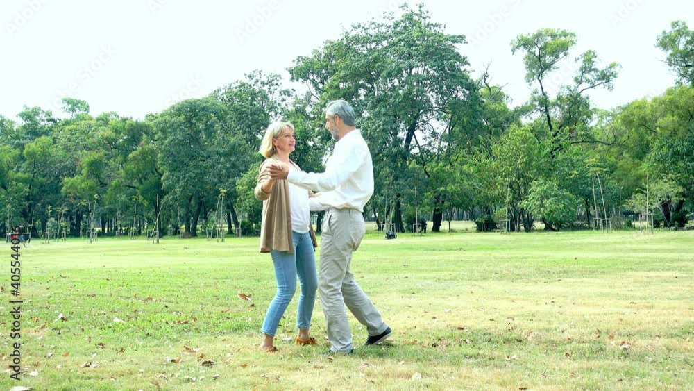 Caucasian senior couple are dancing together in the park. Lover couple. Romantic concept Caucasian senior couple are dancing together in the park. Lover couple. Romantic concept